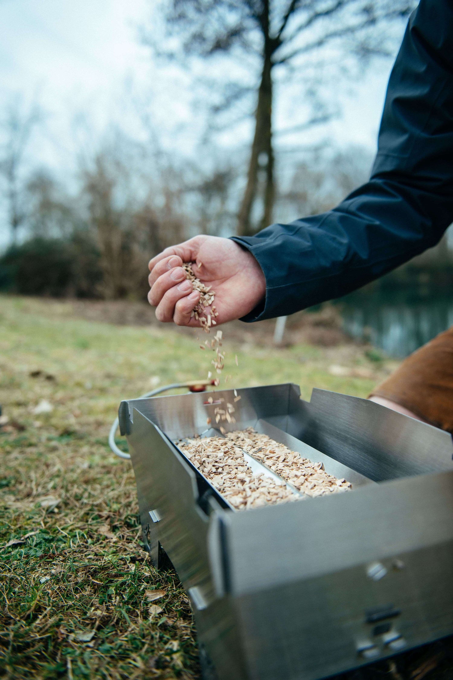 Mann verwendet Räucherspäne um auf dem Skotti Gasgrill zu räuchern